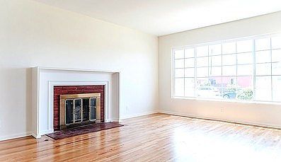 Living room with hardwood floors, dual pane windows and fireplace