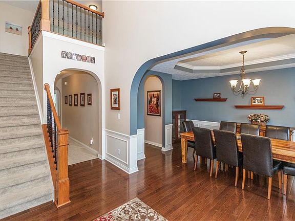 Dining room with tray ceiling, chair rail, and wainscoting.
