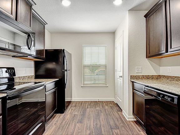 The kitchen features granite countertops and stunning wood cabinetry