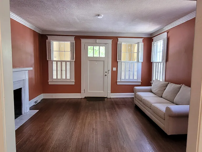 Living Room. Original wood upper and lower shutters in living room, dining room, and all three bedrooms. (Tenant has option to purchase couch, otherwise it will be removed.)