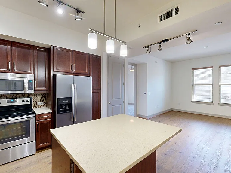 Apartment Kitchen with Quartz counter tops and Wood Style Flooring.