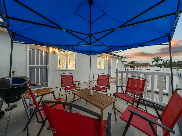 Features a large canopy, comfortable chairs, and a BBQ grill_ideal for casual gatherings and evening conversations