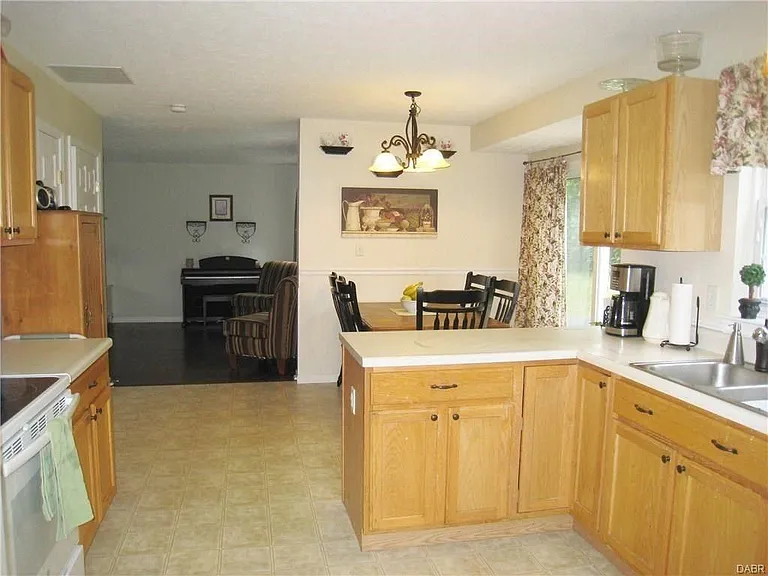 Living room smoothly transitions to dining area, patio door, and spacious kitchen with pantry.