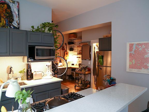 View of the rest of the kitchen (including the refrigerator) into the "breakfast nook," currently used as a WFH space.