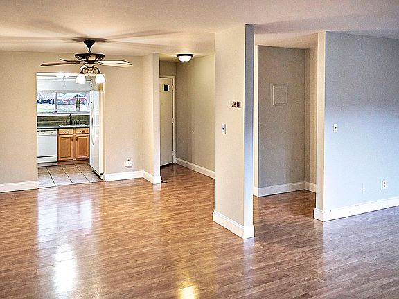 L-Shaped Dining/Living Room view, separate kitchen with large window, refrigerator, range, microwave and dishwasher.