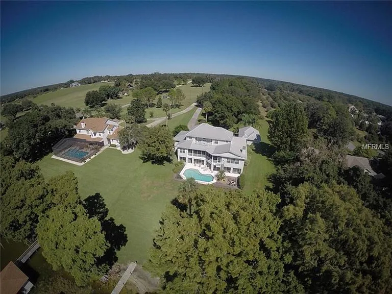 This is an aerial view of the lake side of the house, looking back toward Sunnyside Dr. You can see the three levels each with their decks/patios and spectacular views. the dock and boathouse is beyond the picture frame on lower left
