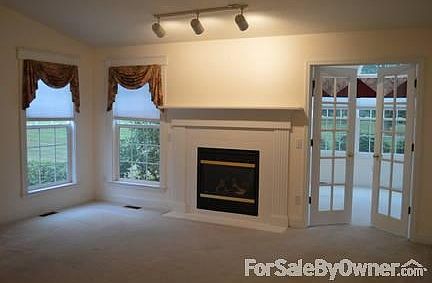 Great Room with Fireplace : Cathedral ceiling in great room with French doors into the garden room.