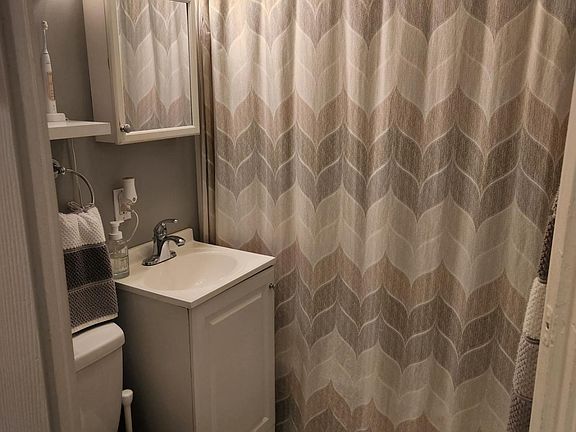 Clean space save bathroom with beautiful marble flooring and new high end tub enclosure.