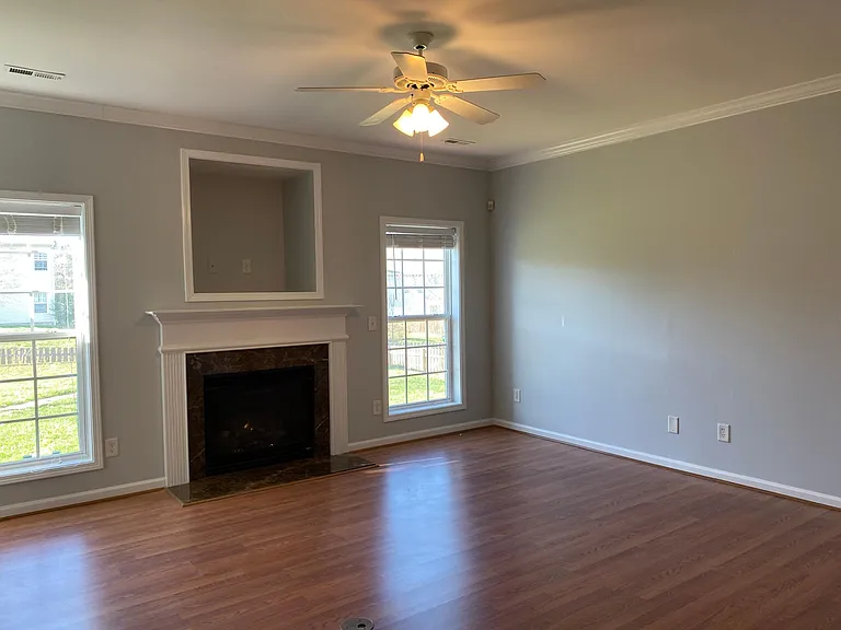 The living-room with gas fireplace and ceiling fan.