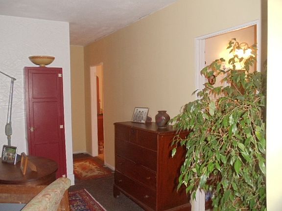 From living room, showing hallway to south/west facing home office or bedroom, with kitchen doorway visible on the right.