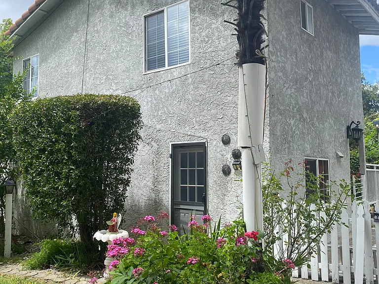 Various fruit trees adjacent to detached townhouse style ADU/ Cottage/ Studio with fenced in yard!