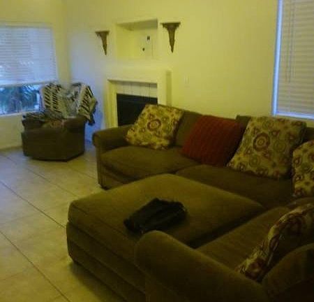 Living room with gas fireplace. Turns on with a flip of a light switch. Shows a sectional and chair fit great !