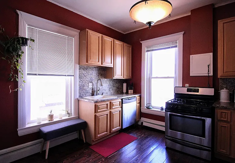 Kitchen with gas range and large windows.