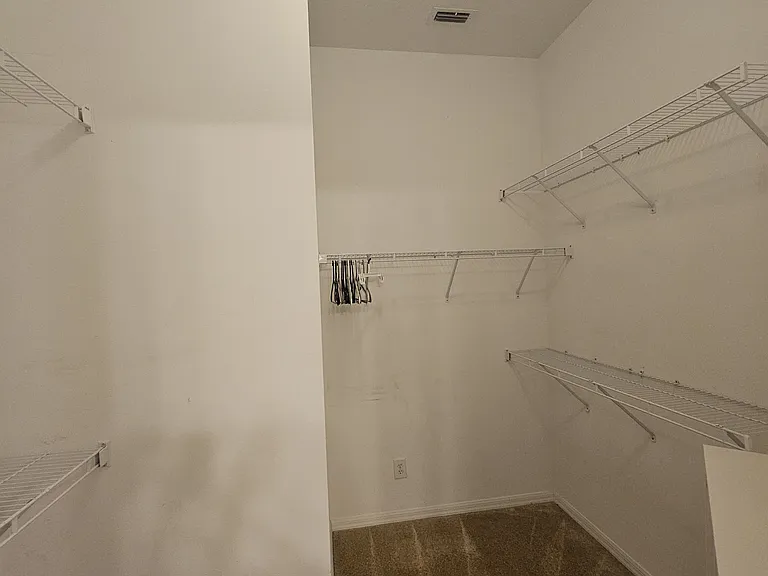 Large walk-in closet in master suite with shoe rack
