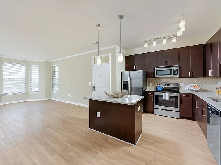 Classic Package II townhome kitchen and living room with hard surface flooring (select homes)