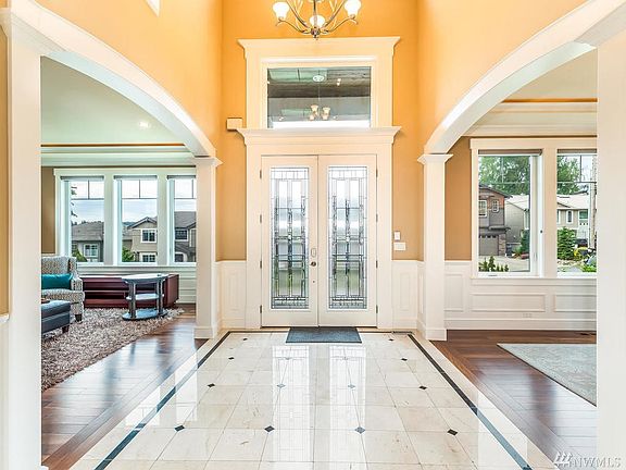Grand two-story entrance welcomes all with inlaid Marble tile floors, Brazilian Cherry hardwoods and leaded glass double-door entry
