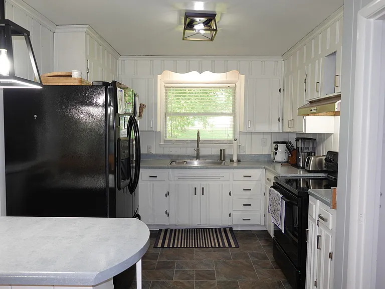 Kitchen includes microwave, oven/range, and refrigerator. New light fixtures, sink, and garbage disposal.
