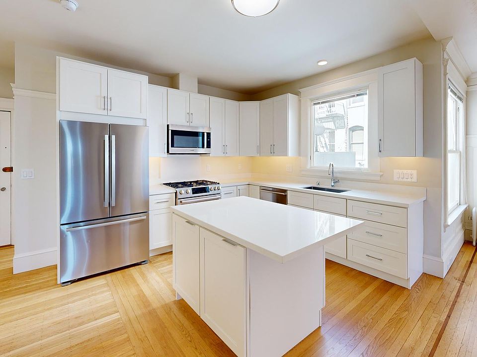 Kitchen with multiple cabinets, refrigerator, stove, and sink