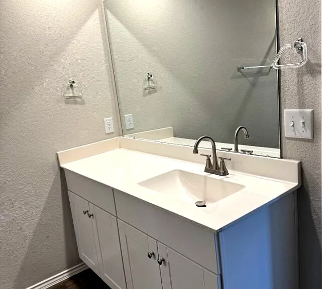 Large vanity area with mirror and storage.