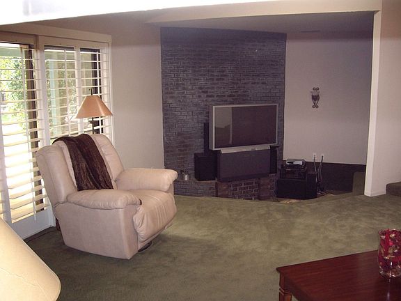 View of family room from kitchen.  Fireplace and submerged "pit" area.