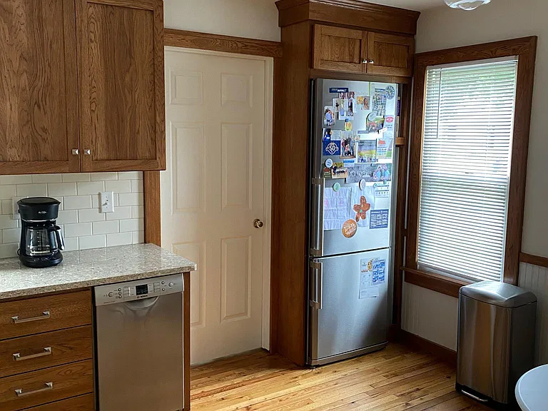 Kitchen with Bosh dishwasher, basement entry, and Blomberg refrigerator and quartz countertop.