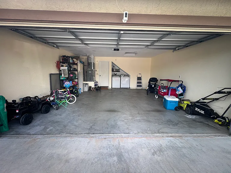 Garage with ample storage space in attic and washer dryer area with hookups