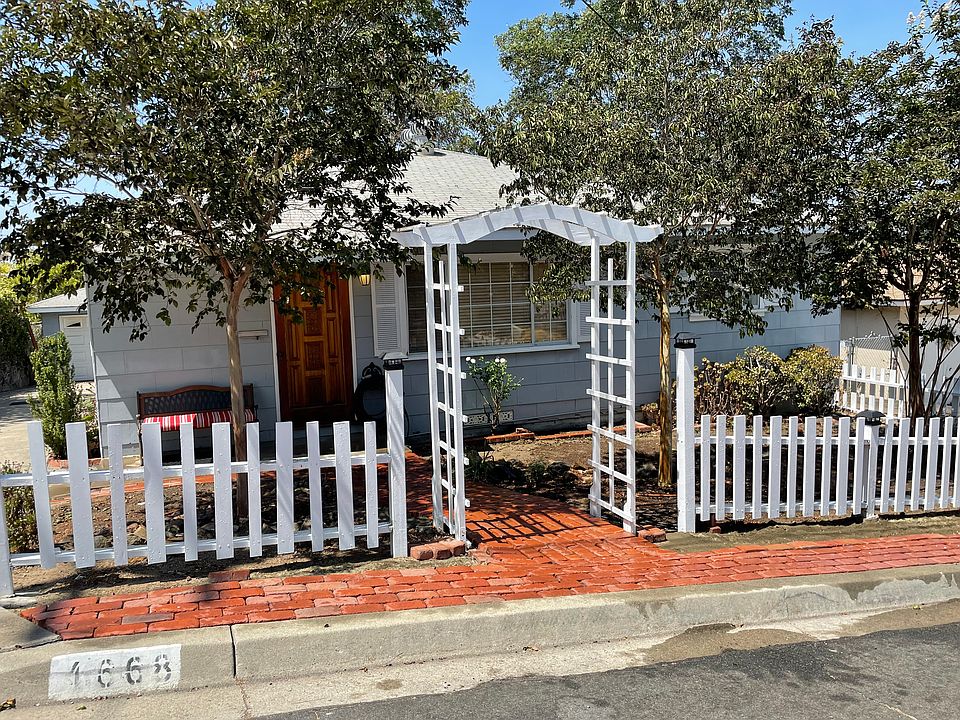 Trellis entry, picket fence, porch bench, water wise front landscaping