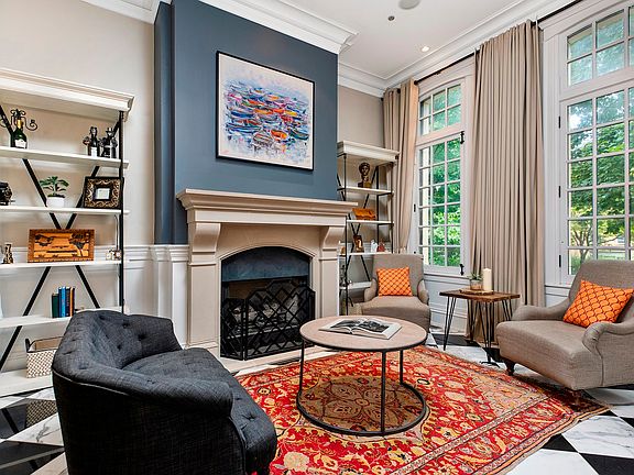 Elegant formal living room with fireplace, marble floors and huge oversized windows