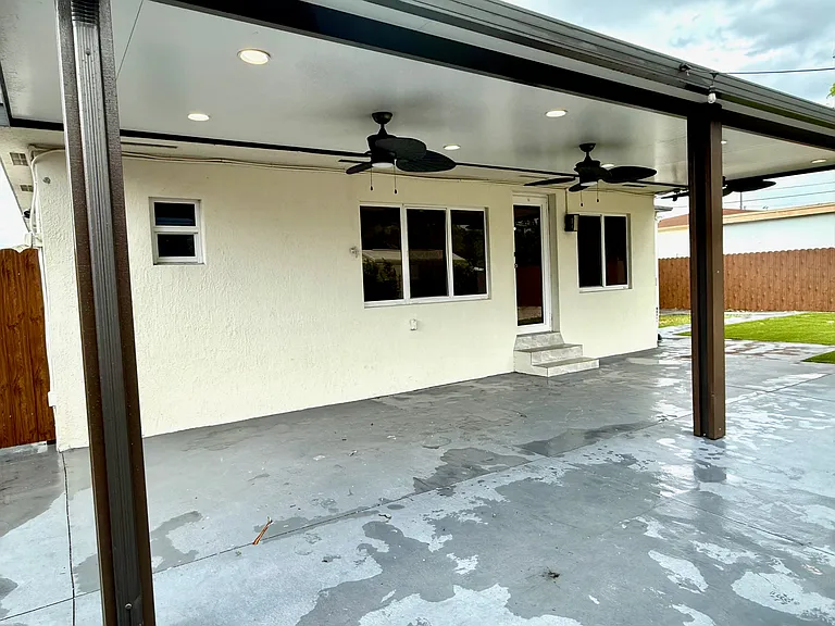 covered patio area w/ outdoor fans and lighting