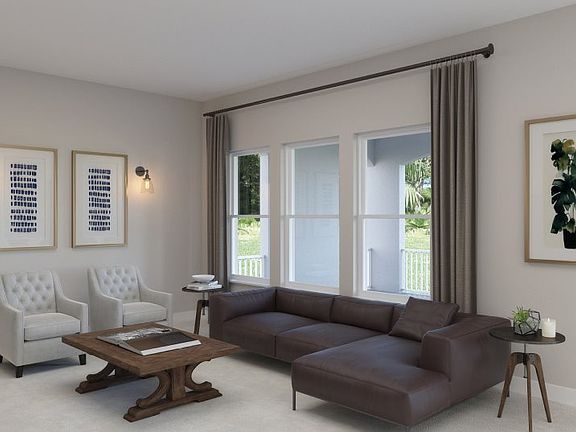 The living room s open design makes it a welcoming space with plenty of natural light from the nearb