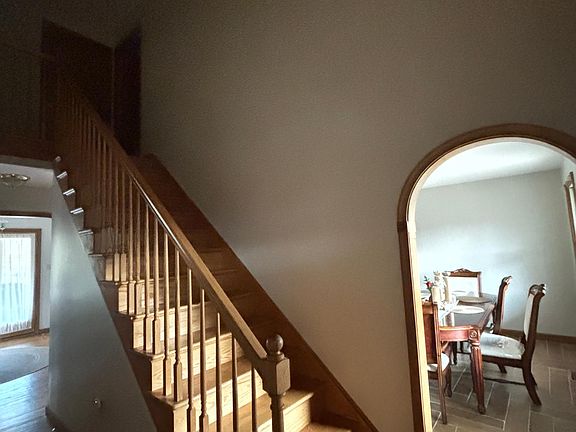 Stairs to go to second floor, with dining room and hallway/entryway shown