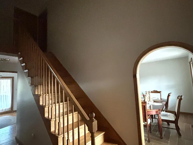 Stairs to go to second floor, with dining room and hallway/entryway shown