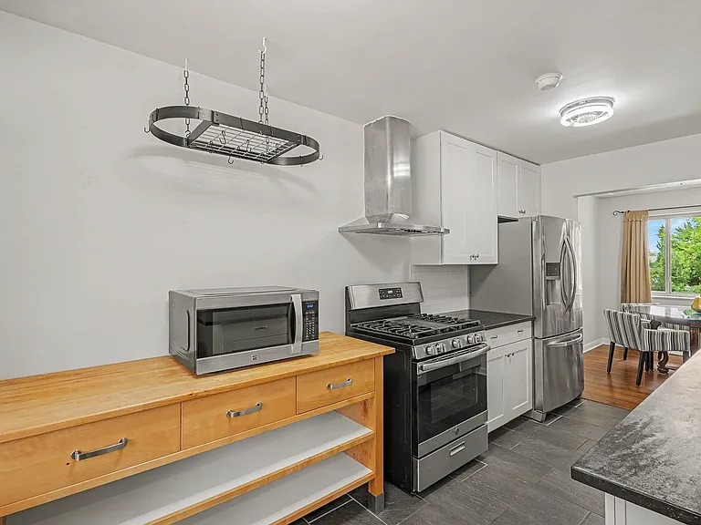Main level kitchen with soapstone counters and sink, stainless appliances, slate flooring
