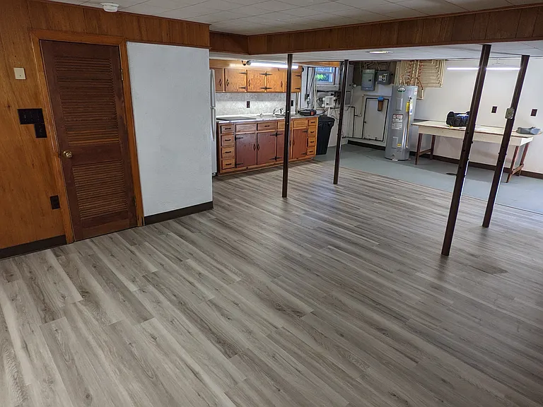 Large open area in basement. Includes kitchenette, laundry hookups. Workbench. Sitting area.