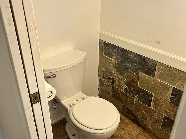 guest bath with stone wainscoting and window
