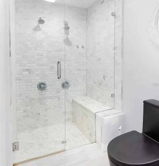 Dual shower heads for the beautifully tiled shower in the primary bathroom.