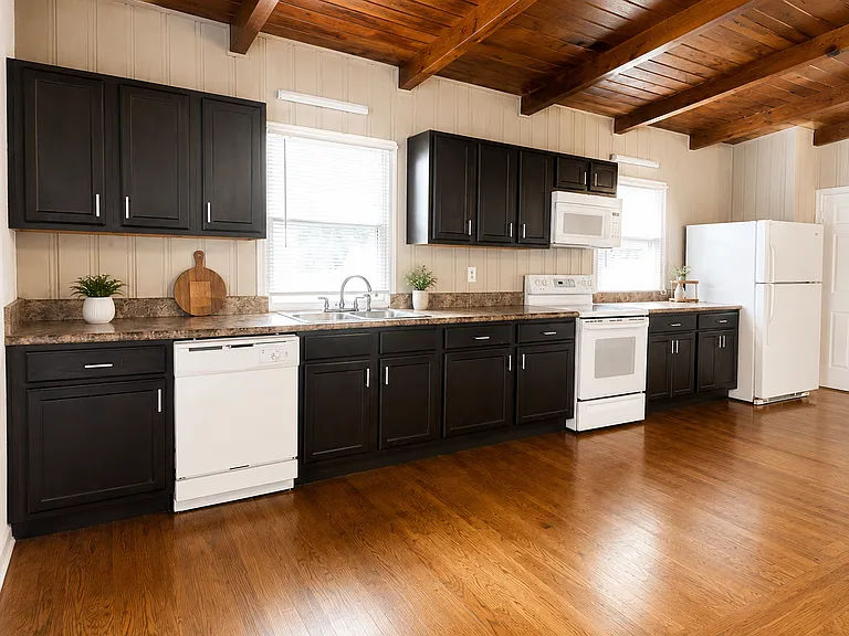 Kitchen with refrigerator, electric range, over-the-range microwave, dishwasher, double sink and generous cabinet and counter space. Select decor is not included.