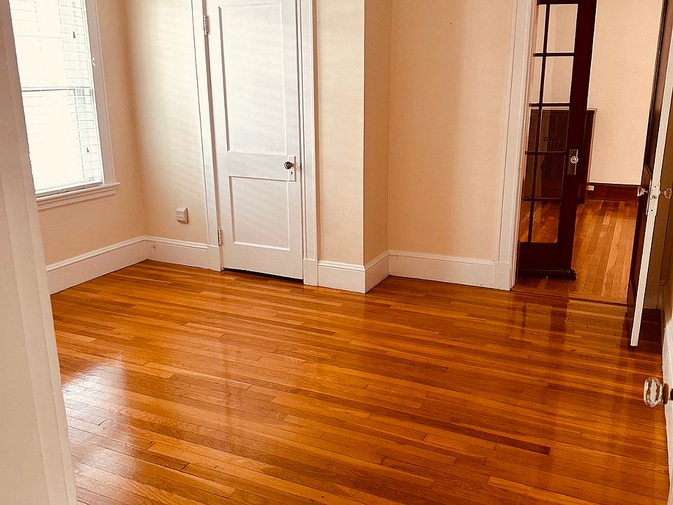 First bedroom with an abundance of natural light and gleaming, hot wood floors.