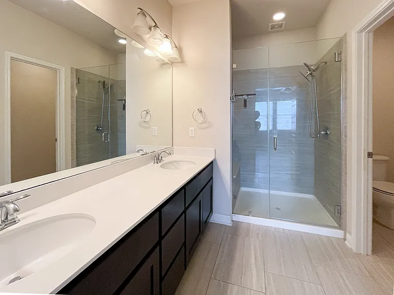 Primary ensuite bathroom with glass shower and separate water closet