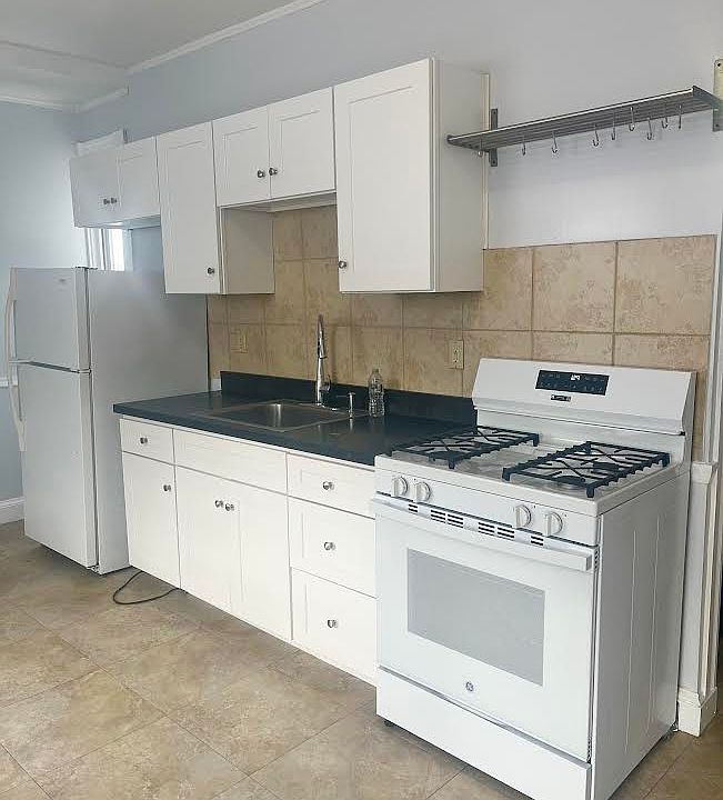 Bright and spacious with a gas stove and bakers rack for pots & pans above the range