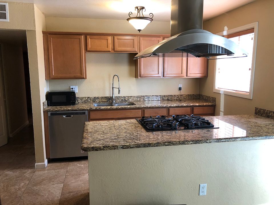 Kitchen with stainless appliances gas stove in island with hood