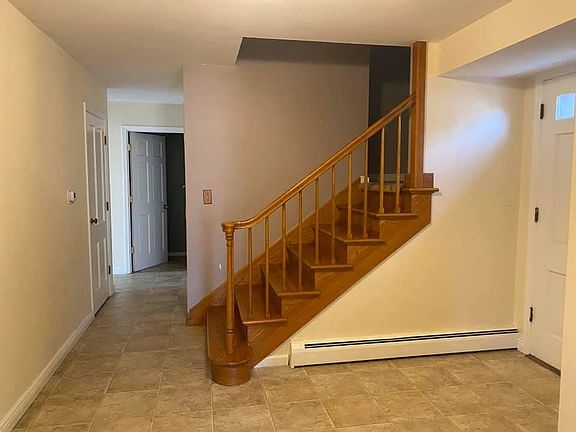 Entryway with stairs to 2nd story and bathroom directly down the hallway