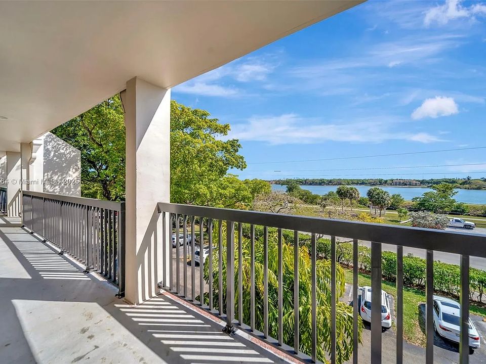 Front walkway, 4th floor, with view of second lake, also visible from front door, kitchen window and secondary bedroom window.
Assigned parking (2 spaces) visible below. Elevator access to all floors from main entrance. Two stairwells on either end.