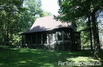 Rear of home showing breakfast room
						:
						five windows with large full glass door leading out onto screened-in porch