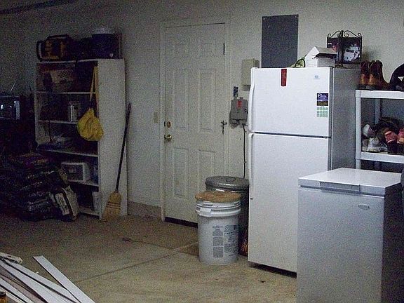 Large 3.5 garage with sink and door to backyard and storm shelter