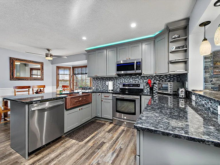 Spacious kitchen with abundant cabinetry, granite counters, stainless appliances, and a convenient breakfast bar.
