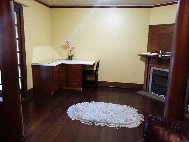 Open-concept living and dining room area with cozy decorative fireplace opens to a spacious balcony running the length of the building.