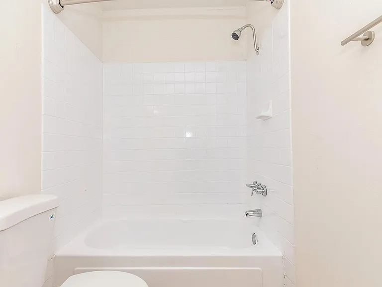 Bathroom with white bathtub and tiled backsplash