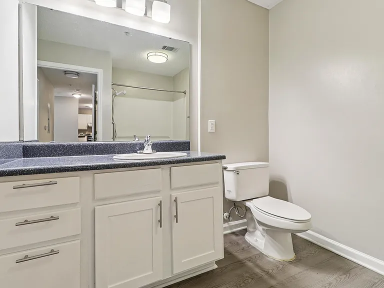 Clean, functional bathrooms feature toilet, sink, and mirror with quality fixtures, professionally operated by Highlands Vista Group.