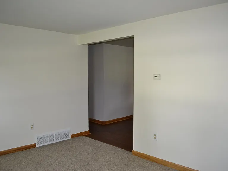 Door frame leading out of living room; it leads back to the dining area. The hall to the left leads to bedrooms.